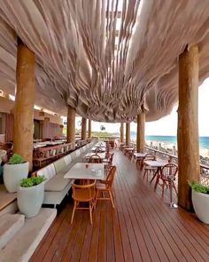 an outdoor dining area with tables and chairs on the beach side, overlooking the ocean