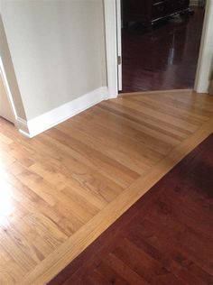 an empty room with hard wood flooring and white walls, looking into the hallway