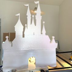 a castle made out of ice sitting on top of a table next to a window