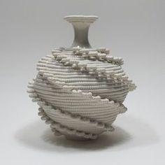 a white vase sitting on top of a table