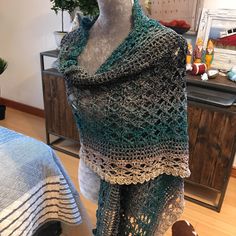 a knitted shawl draped over a mannequin's head