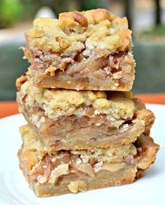 a stack of dessert bars sitting on top of a white plate