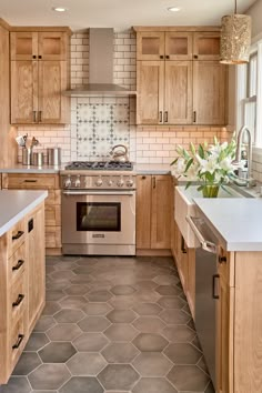 a kitchen with wooden cabinets and tile flooring in the center, along with stainless steel appliances