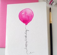 a pink balloon with the words happy birthday written on it next to a brush and marker