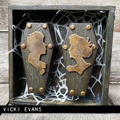 two wooden doors with metal knobs are shown in an old wood box on the table