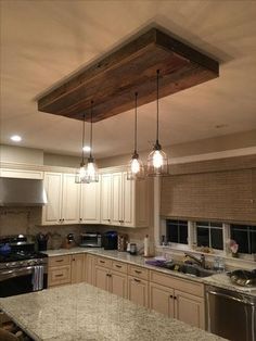 a kitchen with marble counter tops and wooden beams hanging from the ceiling over the stove