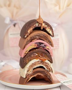 a stack of chocolate covered donuts sitting on top of a white and pink plate