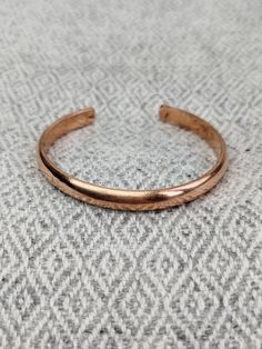 This Hand Forged 100% Pure Copper Bracelet is a stunning piece of jewelry that boasts of solid copper construction, making it ideal for anyone looking for an Arthritis Relief Bracelet. It features a wrap-style setting that is handmade and crafted in Nepal by Shaney Entreprise, a reputable brand in the industry. The cuff-style bracelet is perfect for both men and women and comes with a copper purity of 100%. The bracelet comes in a beautiful copper color, and it has no stones, making it an excell Handmade Rose Gold Copper Cuff Bracelet, Hand Forged Copper Bangle Bracelet, Handmade Copper Bangle Bracelets, Spiritual Bronze Copper Cuff Bracelet, Hammered Copper Bangle Bracelets, Hammered Copper Bangle Bracelet, Gold Electroformed Bracelets For Gift, Rose Gold Copper Bangle Cuff Bracelet, Rose Gold Copper Cuff Bangle