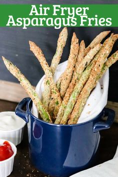 air fryer asparagus fries in a blue pot with ketchup on the side