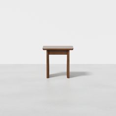 a small wooden table sitting on top of a white floor