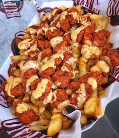 a basket filled with lots of food covered in sauce and meatballs on top of it