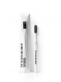 a black and white photo of a toothbrush in a tube on a white background