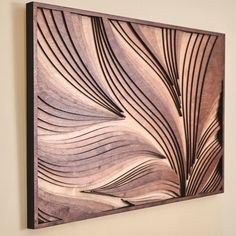 a wooden wall hanging on the side of a wall with an abstract design in it