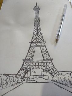 a drawing of the eiffel tower on paper with a pen next to it