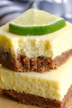 two pieces of cheesecake are stacked on top of each other with a lime slice