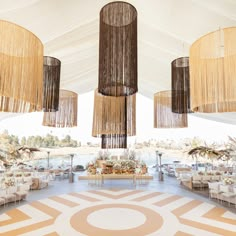 the inside of a tent with chandeliers and tables