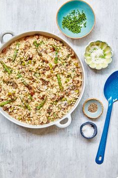 a casserole dish filled with rice, peas and other ingredients on a table