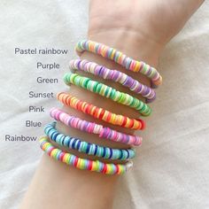 a person's arm with five different colored bracelets on it and the words pastel rainbow, purple, green, sunset, pink, blue, rainbow