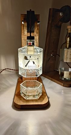 a glass bottle sitting on top of a wooden stand next to an old fashioned clock