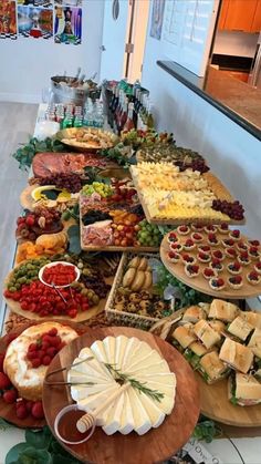 a long table filled with lots of different types of cheeses and other food items