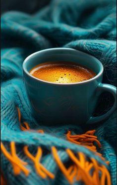 a cup of hot chocolate sitting on top of a blue blanket