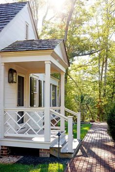 a small white house with porch and steps