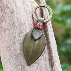 a keychain with a leaf shaped metal object hanging from it's side