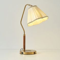 a table lamp with a wooden base and a white shade on the top of it