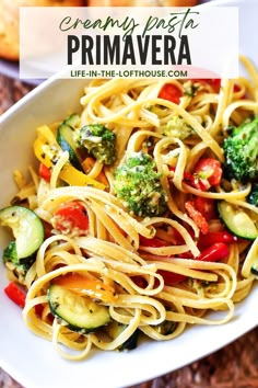 a white bowl filled with pasta and vegetables