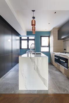 a kitchen with marble counter tops and wooden flooring, along with blue painted walls