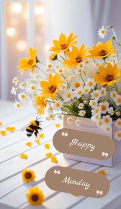 a vase filled with white and yellow flowers next to a bee on top of a table