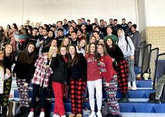 a large group of people standing on the bleachers in matching pajama pants