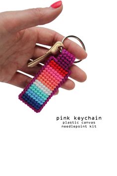 a hand holding a keychain made out of multicolored beads with a pair of scissors