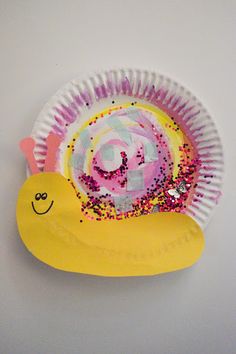 a paper plate with a snail on it and sprinkles all over it