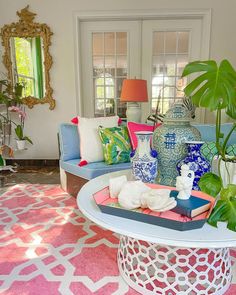 a living room filled with lots of furniture and decor on top of a pink rug