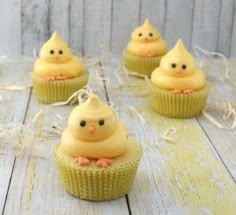 small cupcakes with yellow frosting and pink bows on them sitting on a table