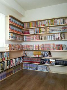 a room filled with lots of different types of dvd's on shelves next to a window