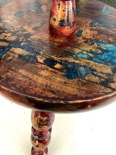 an old wooden table with some paint on it and a vase sitting on top of it