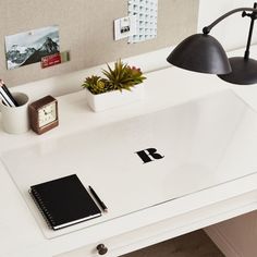 a desk with a laptop, phone and other office supplies on it in a home office