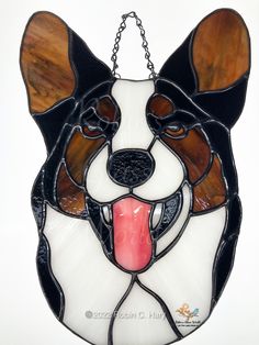 a stained glass hanging decoration with a dog's face and tongue sticking out from its mouth