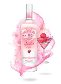 a bottle of vodka next to a martini glass filled with raspberry sorbet