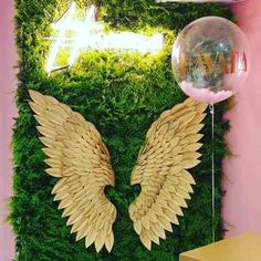 a wall with an angel wing decoration and a balloon