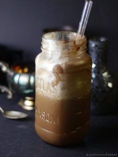 a mason jar filled with ice cream and topped with two spoons