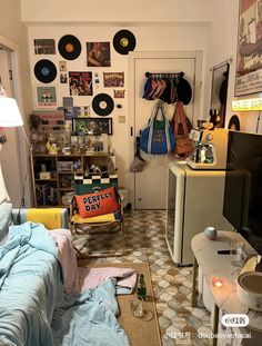 a bed room with a neatly made bed and lots of records on the wall behind it