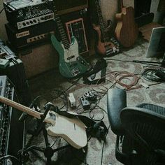 a room with guitars, amps and other musical equipment on the floor in it