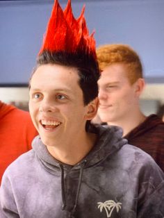 a young man with red hair wearing a grey hoodie