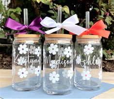 three mason jars decorated with flowers and ribbons