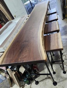 a long wooden table sitting on top of a metal frame in a room filled with other furniture