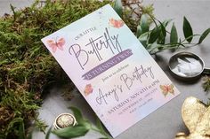 a butterfly themed birthday party is set up on the ground next to some green plants