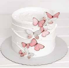 a white cake with pink butterflies on it